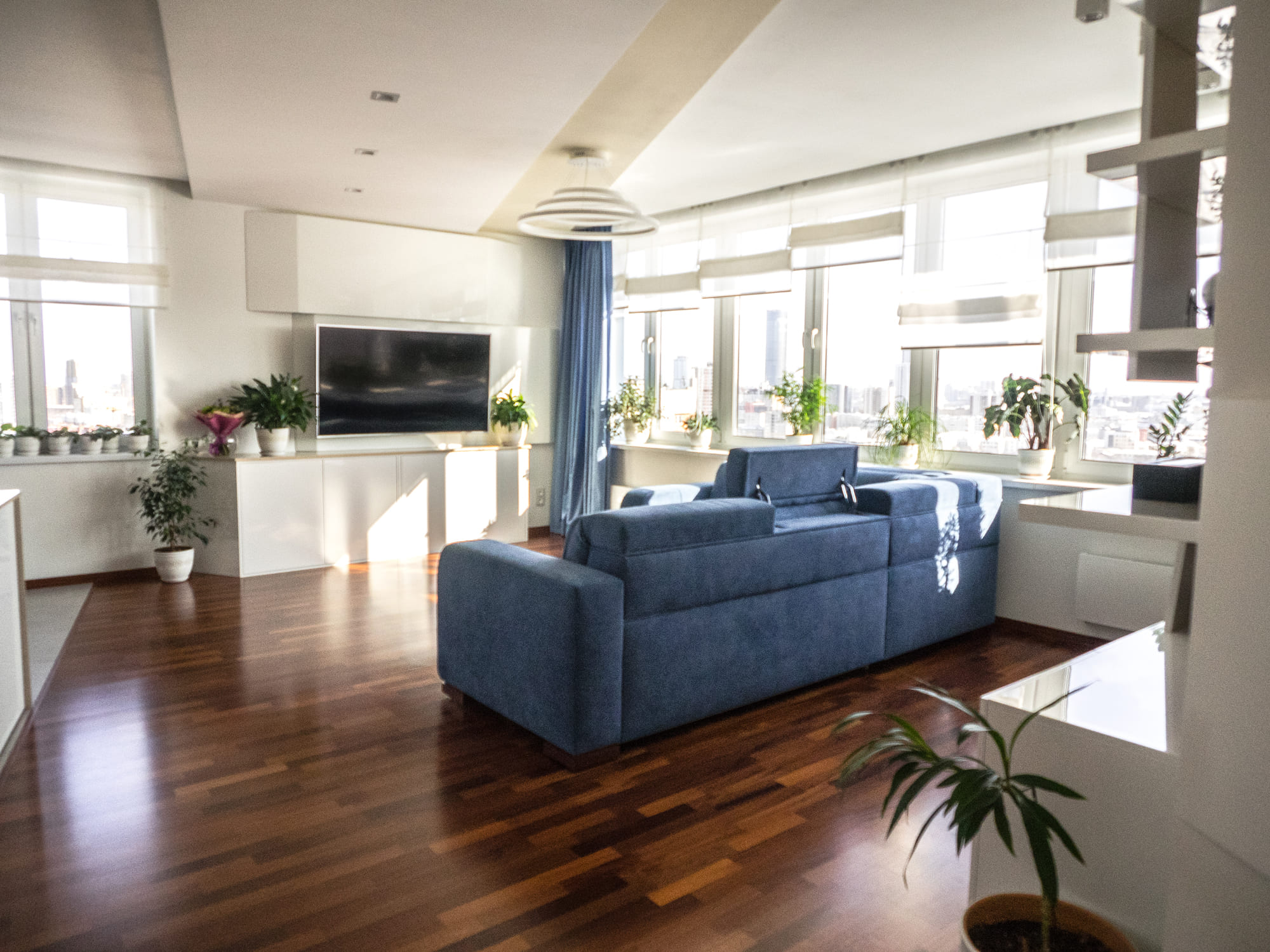 divan_v_gostinoy_s_panoramnym_oknom_i_kompozitsia_s_televizorom